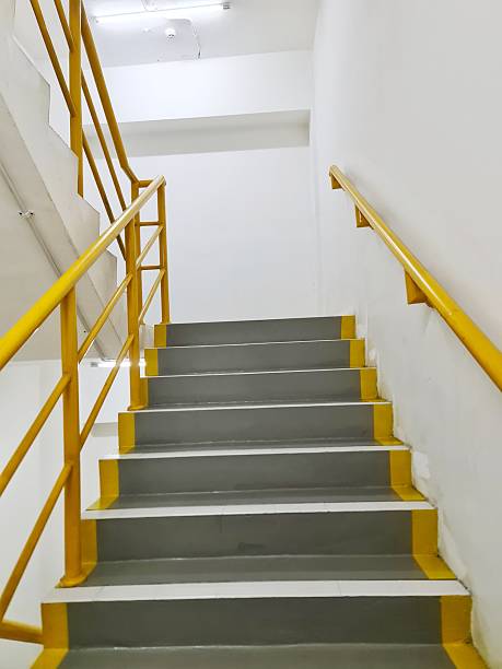 istock A gray painted stairway leads upward with bright yellow 2248798991