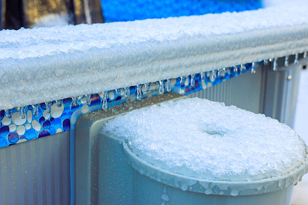 istock Icicles form on edge of pool during winter, cold weather in suburban backyard setting 2248800351
