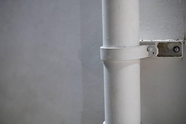 istock White PVC pipes are installed on the concrete wall with straps. 2248800555