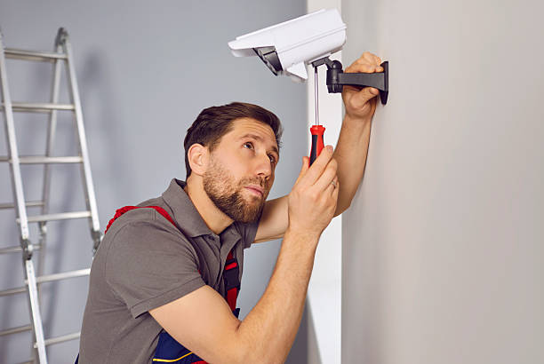 istock Man worker setting up a surveillance camera on the wall inside the house or apartment 2248802738