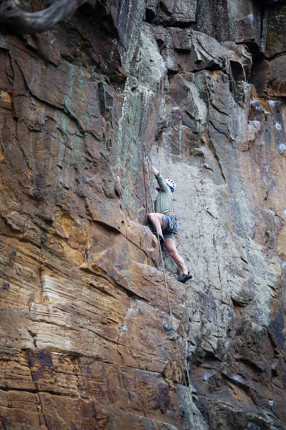Muscular rock climber climbing outdoors