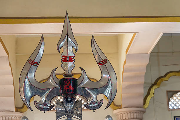 ornate holy metallic shiva trishul displayed inside hindu temple interior