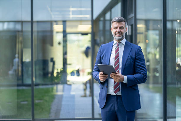 istock Smiling businessman using digital tablet in modern office building 2248808195
