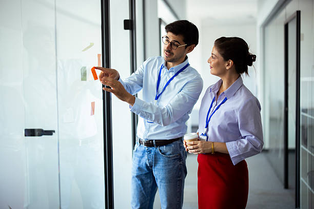 istock Business colleagues discussing notes on glass wall in office 2248808422