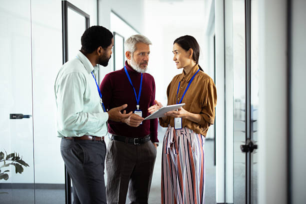 istock Business people collaborating using digital tablet in office corridor 2248811533