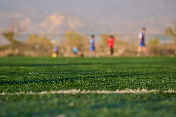 Young athletes practice soccer in the sun.