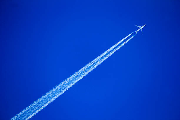 istock An airplane leaves a long contrail across a clear blue sky 2248813655