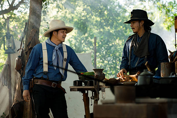 istock Cowboys gather around a chuck wagon preparing fresh ingredients for cooking 2248815326