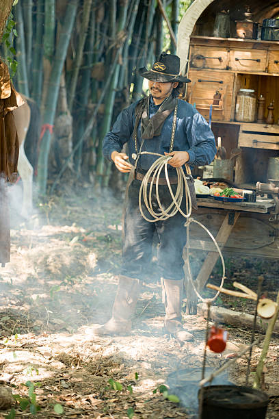 istock A cowboy handling a lasso rope for training at a rustic camp setup with wooden storage 2248815458
