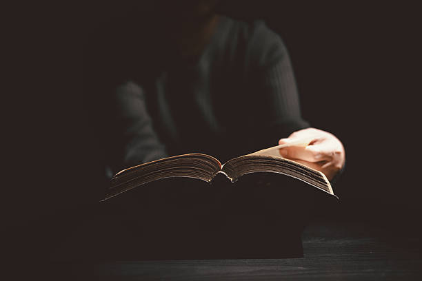 istock Hands holding and offering the Holy Bible with dramatic light in darkness, symbolizing Christianity, faith, gospel truth, worship and hope. Concept of God Word bringing light to life. 2248816040