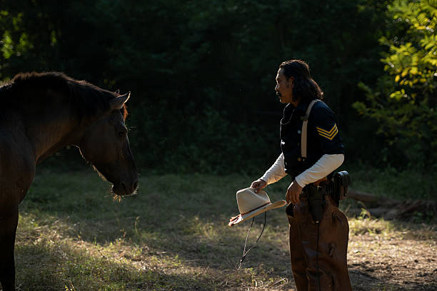 A cowboy gently touching his horse in warm evening light, creating a calm and intimate western moment