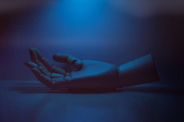 Wooden artist's mannequin hand with palm up, depicting vulnerability and a request for help in blue light