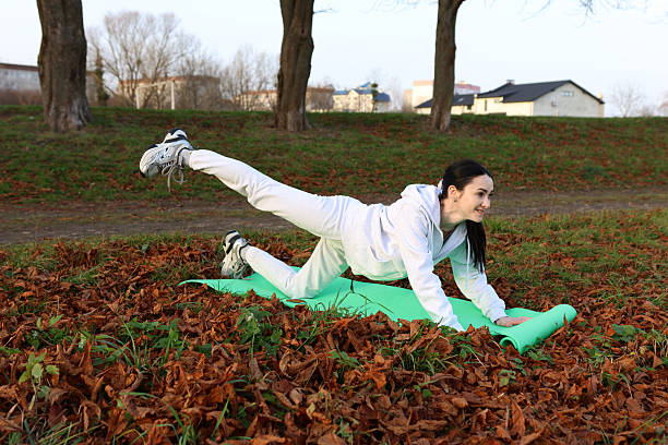 A beautiful sportswoman is jogging in a public park while enjoying music using headphones.