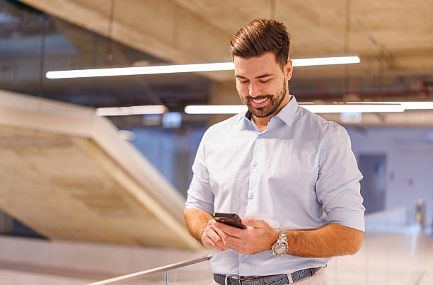 istock Smiling professional businessman using smartphone in modern office 2248826460