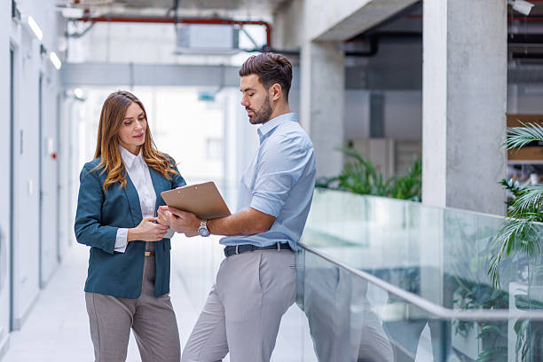 istock Business colleagues discussing data on clipboard in office hallway 2248826597