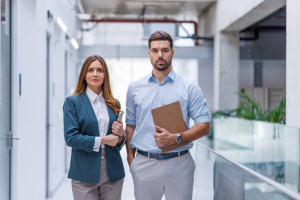 istock Confident business professionals standing in modern office corridor 2248826639