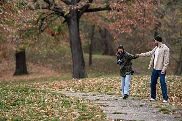 istock Couple holding hands walking park autumn foliage 2248827910