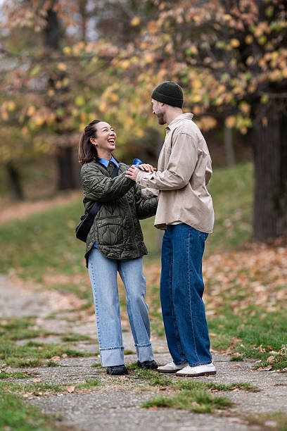 istock Happy couple laughing and holding hands in park 2248827946