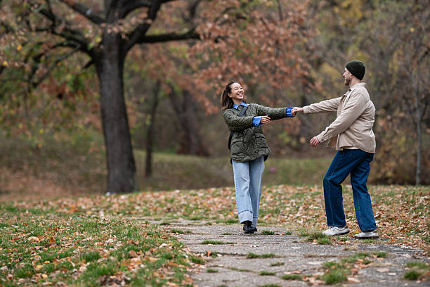 istock Happy couple dancing in autumn park holding hands 2248828032
