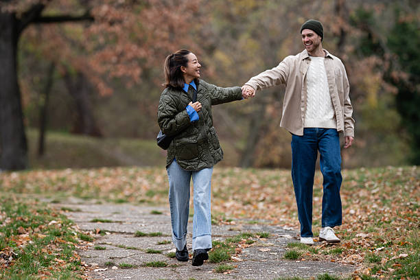 istock Happy multiethnic couple holding hands walking in autumn park 2248828079