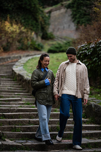 istock Young couple holding hands walking down stone stairs 2248828369