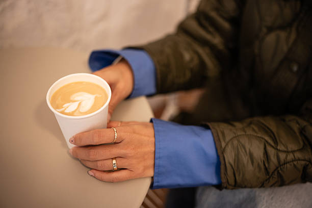 Woman's hands holding coffee cup with latte art
