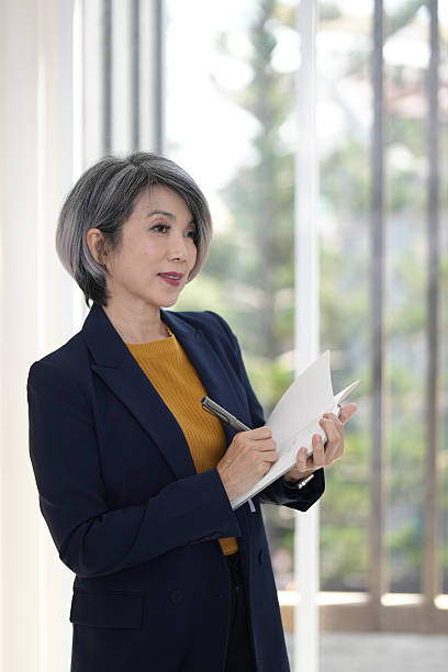 istock Senior Asian businesswoman taking notes strategizing business growth professional development bright modern office environment 2248829185