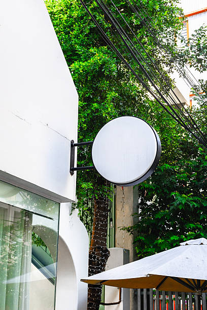 istock Blank round sign on building facade with greenery 2248829414