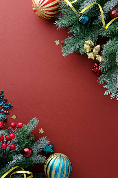 istock Christmas banner. Vertical corner decoration on red background with pine branches, vintage baubles, red berries and festive ornaments. 2248829531