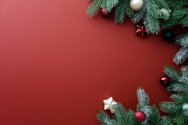 istock Christmas banner template. Top view pine branches with baubles on rich red background. Xmas greeting card. 2248830212