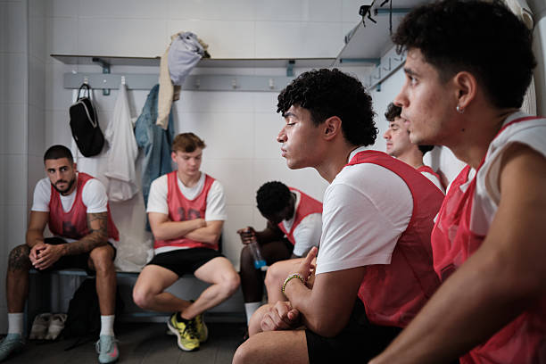istock Male athletes thinking in dark locker room before game 2248830391