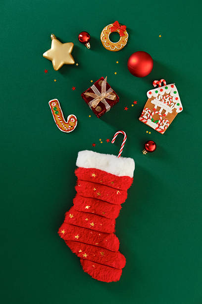 istock Red Christmas stocking and gingerbread cookies on emerald green vertical background. 2248830454