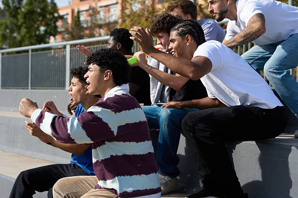 istock Young men cheering sports game in bleachers 2248830500