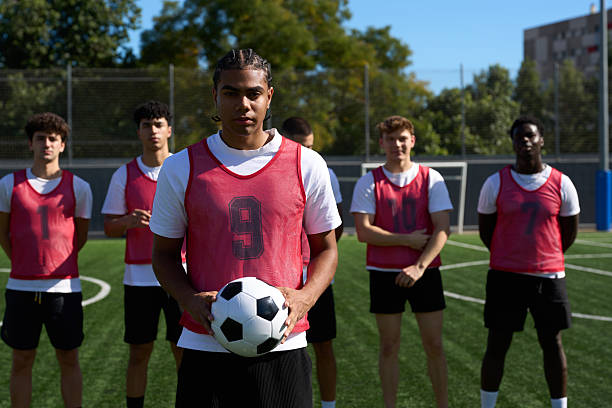 istock Soccer player holding ball with diverse team standing 2248830538