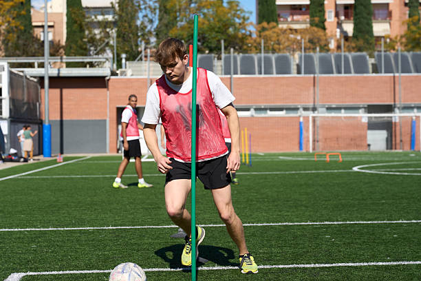 istock Male soccer player training dribbling agility drills on practice field 2248830587