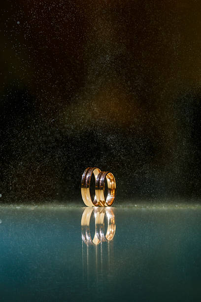 Wedding rings with water droplets,The engagement ring set.,Beautiful silver background with wedding rings and stars