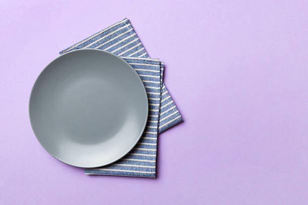 istock Top view on colored background empty round gray plate on tablecloth for food. Empty dish on napkin with space for your design 2248834476