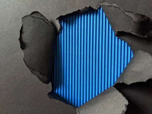 A bright blue sheet peeks through torn black paper, creating a striking contrast perfect for announcements, creative design or concept imagery. Ideal for themes of reveal, surprise and modern style
