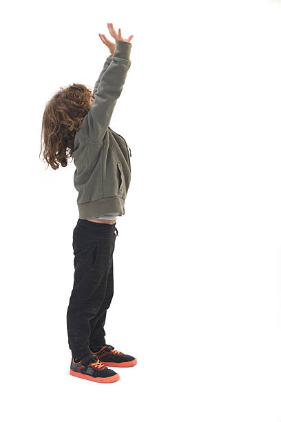 istock side view of  child squeezing or holding something imaginary from the ceiling against a white background 2248835246
