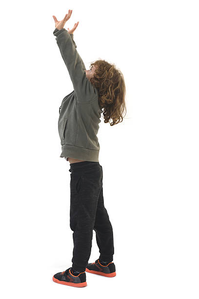 istock view of  child squeezing or holding something imaginary from the ceiling against a white background 2248835251