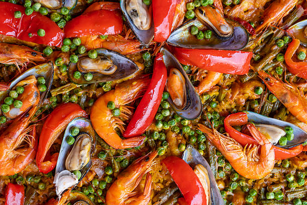 Spanish seafood paella in fry pan with mussels, shrimps and vegetables