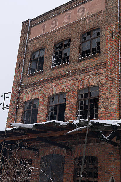 Zbazyn, Poland - November 26, 2025: Close-up of an abandoned brick factory wall showing the year 1939 above broken windows. Concept of architectural history, aging infrastructure, heritage research and archival materials.