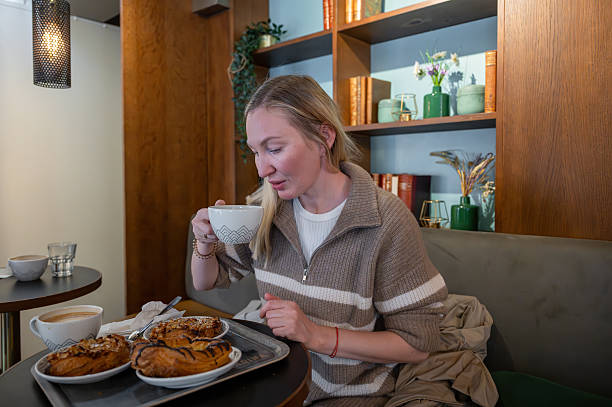woman enjoying coffee and pastries in cozy cafe