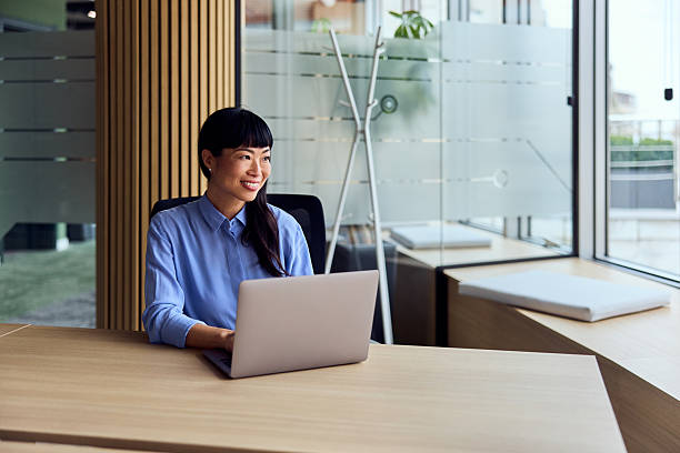 istock Asian Woman in Modern Workspace Working on Laptop in Bright Open Office 2248839008