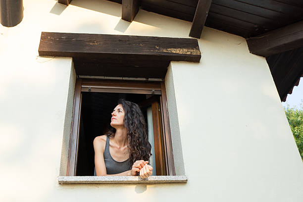 istock Woman looking out window thinking enjoying sunlight 2248839459