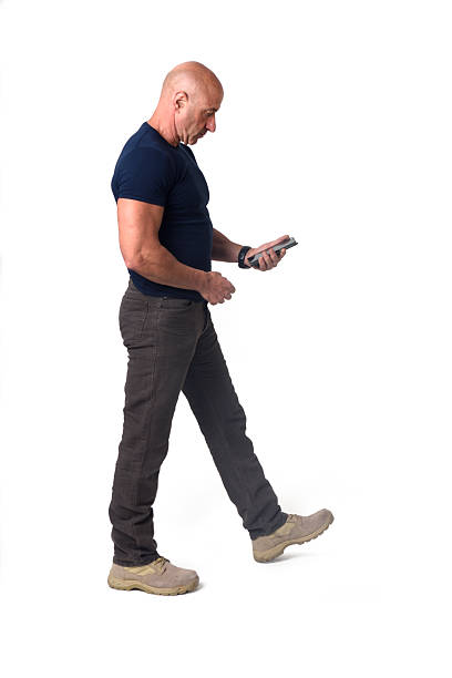 istock side view of walking man looking at her mobile phone on white background 2248840259