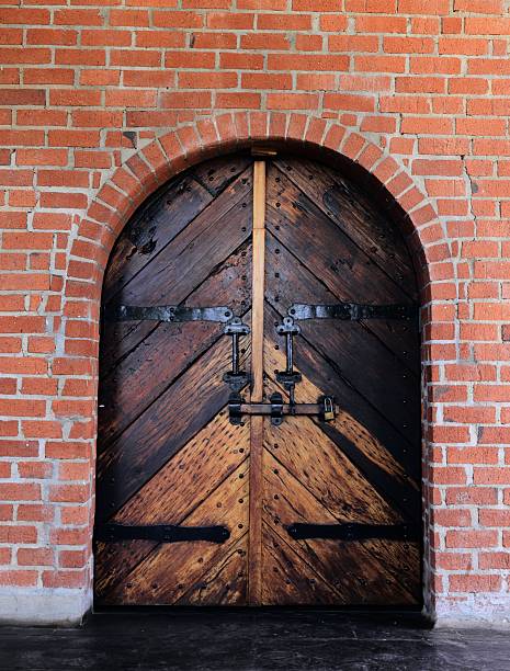 An ancient wooden gate in a red brick fortress wall