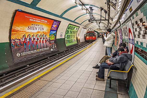 Empty tiled tunnel in the London Underground, featuring fluorescent lights and perspective lines. London, UK, 26 December 2023