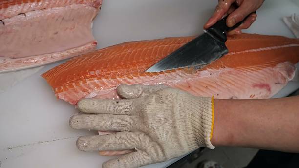 istock Fresh salmon fillet with precise knife cut in professional kitchen 2248846434