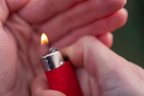 Photo of two female hands protecting a lighter flame from wind on a blurred background, perfect for wallpapers, prints, decor, and creative projects